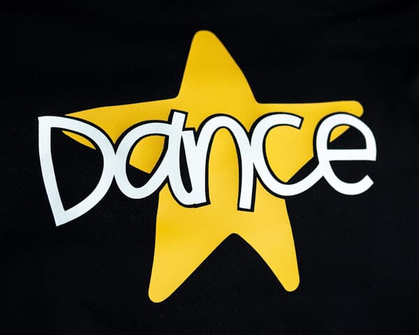 A design that reads "Dance" with a star before being stretched made using White and Yellow ThermoFlex Stretch