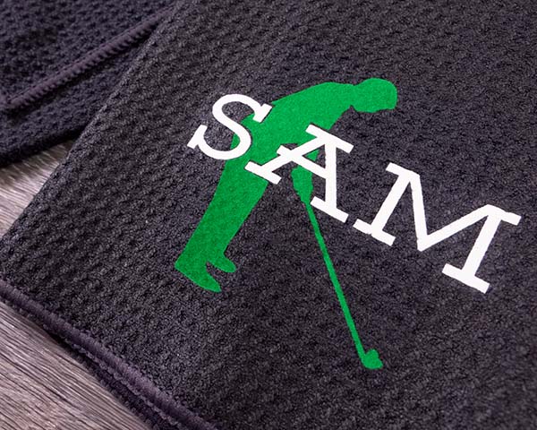 A towel with a golfer and the name "Sam" made with Bright Green and White Premium DecoFlock