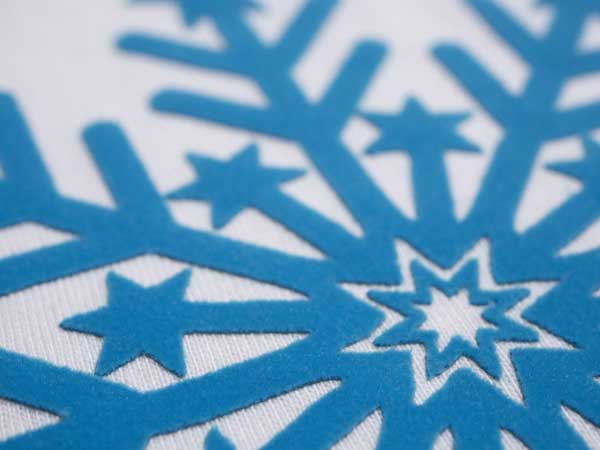 A close up picture of a snowflake made using Neon Blue DecoFlock Premium Plus
