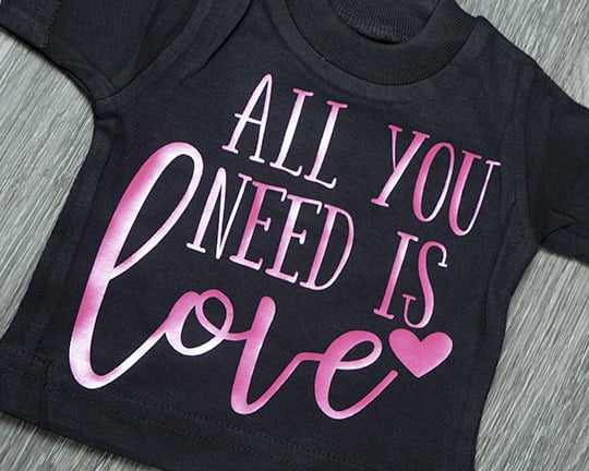 A shirt reading "all you need is love" made using Watermelon DecoFilm Paint FX