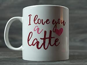 The finished mug reading "I love you a latte" made in Red and Rainbow Red Pressure Sensitive GlitterFlex Ultra