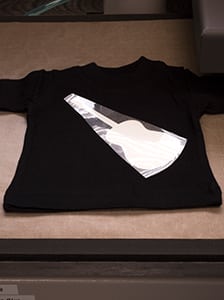 The guitar outline in GlitterFlex Ultra being pressed onto a shirt before being sublimated