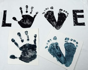 A finished shirt that had traced a hand and foot print to create the word "LOVE"