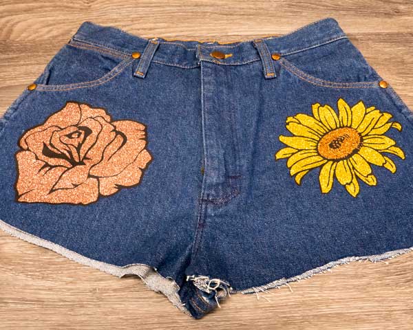 A pair of jean shorts with a rose and flower made from GlitterFlex Ultra and ThermoFlex Plus