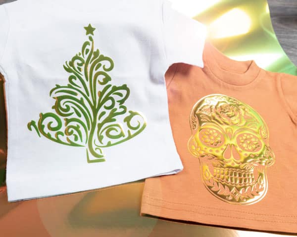 A Christmas tree and sugar skull design on two mini-ts made with Green DecoFilm Brilliant Chameleon