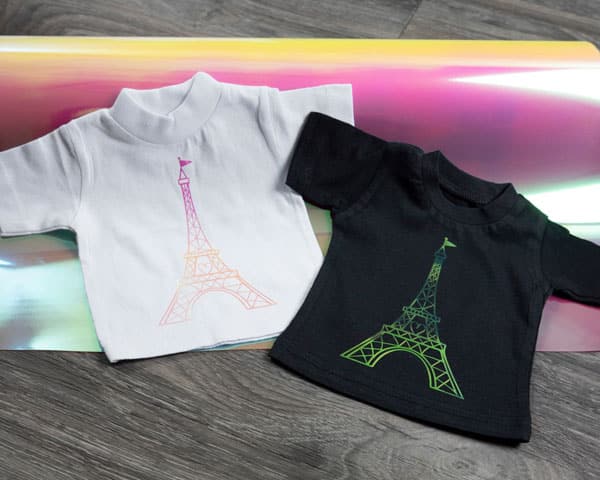 An Eiffel Tower design on two different colored mini-ts to show how the DecoFIlm Brilliant Chameleon looks on different colored tees in Pink DecoFilm Brilliant Chameleon