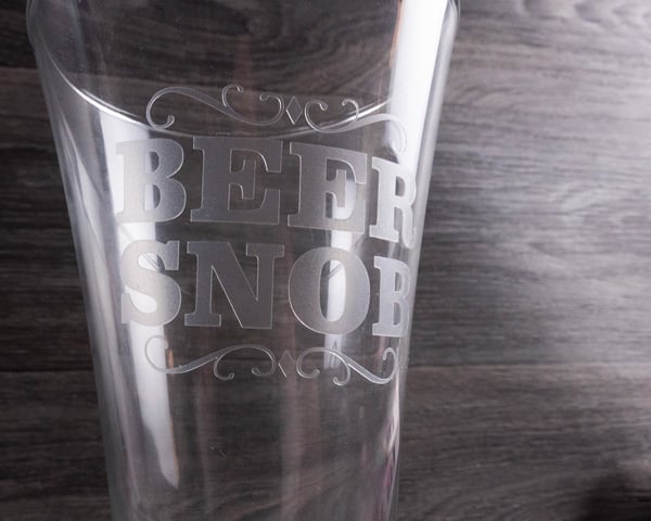 A beer glass reading "Beer Snob" made with White Etched