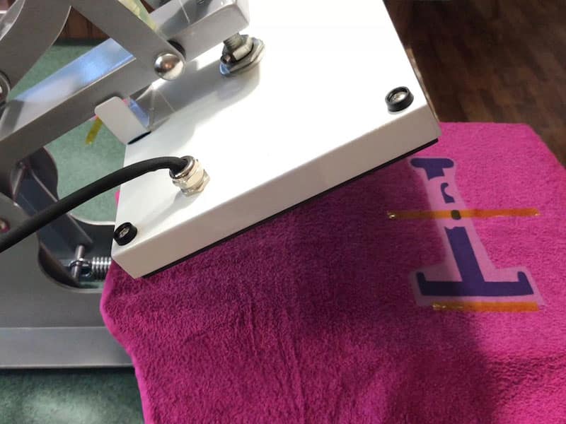 Pressing the larger uppercase letter of the monogram onto the towel