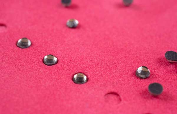 A cut piece of Rhinestone Flock with rhinestones being put into place.