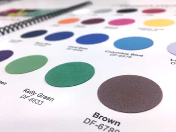 Photo showing the inside of Specialty Materials' Product Color Guide that use real material swatches