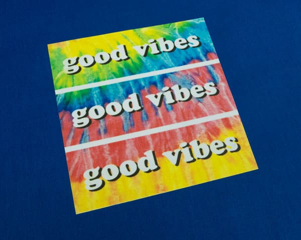 The words "good vibes" on a tie dye background sublimated onto SubliFlex®