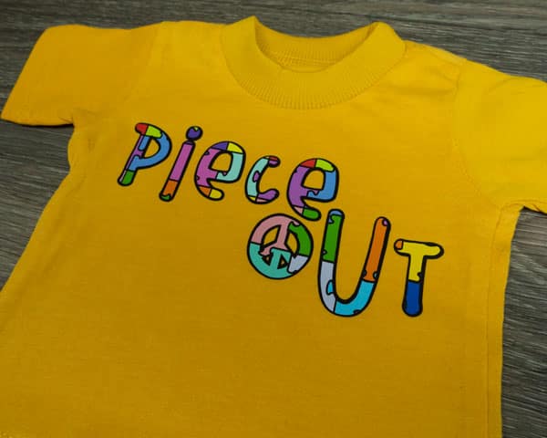 A shirt that reads "piece out" made with Jigsaw Multicolor ThermoFlex® Fashion Patterns and Black ThermoFlex® Plus